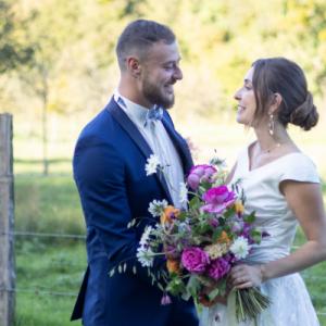 Photo de mariés dont la mariée tient un bouquet de fleurs fait par Elven Garden Flower, fleuriste de mariage à Caen - Mariage en Normandie