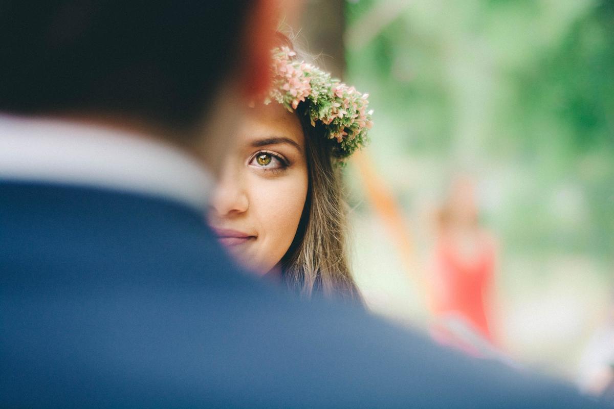 Une femme qui regarde son mari lors d'un mariage avec une couronne de fleur dans ses cheveux