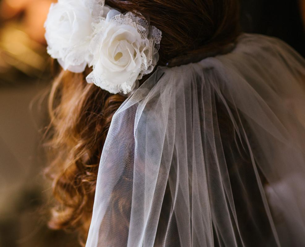 Photographie d'une mariée ayant un voile blanc comme accessoire de mariage 