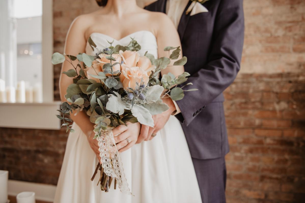 Couple avec un bouquet de fleurs pour leur mariage 