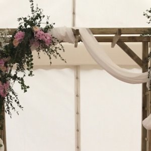 une arche avec des fleurs et du tissus pour le jour J  - Mariage en Normandie