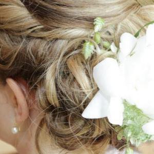 Photo d'un chignon fantaisie de mariage avec une fleur pour décorer la coupe de cheveux en Normandie  - Mariage en Normandie